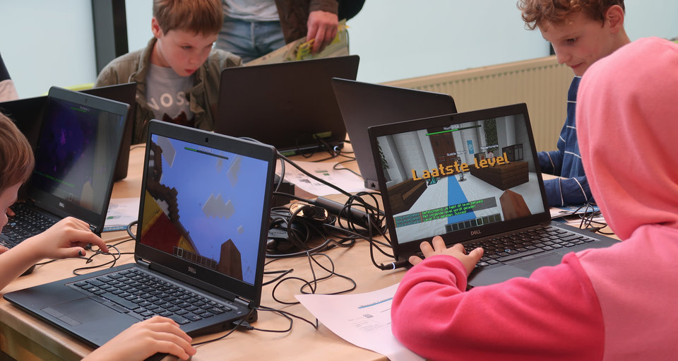 Kinderen leren tijdens een scholenworkshop leren programmeren in Minecraft