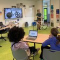 Marco Reijne, fietsdynamica expert TU Delft, vertelt basisschool leerlingen alles over de Olympische baanfiets